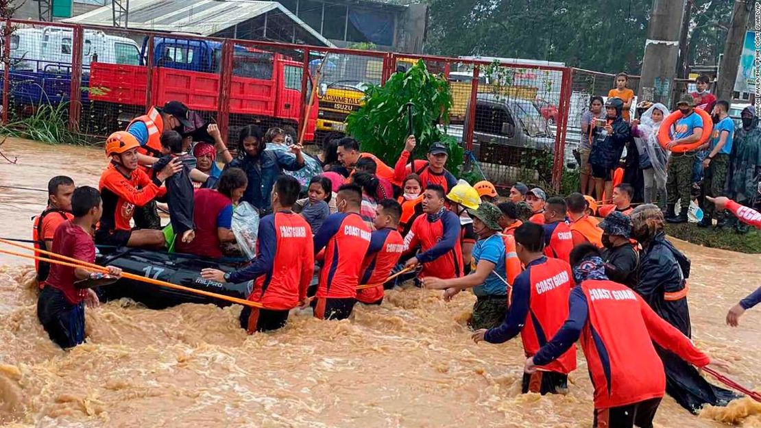 Socorristas ayudan a los residentes a superar las inundaciones causadas por el tifón Rai mientras son evacuados a terrenos más altos en la ciudad de Cagayan de Oro, al sur de Filipinas, el 16 de diciembre de 2021.