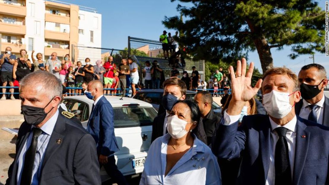 El presidente Emmanuel Macron saluda a los vecinos del barrio de Bassens junto al alcalde de Marsella, Benoit Payan (centro), durante una visita a la ciudad portuaria del sur, el 1 de septiembre de 2021.