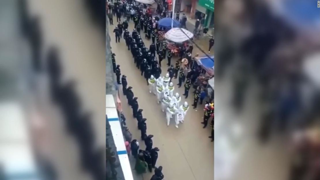 Los sospechosos desfilan por las calles, rodeados por la policía y una multitud de curiosos.