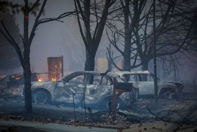 LOUISVILLE, CO - 30 DE DICIEMBRE: Vehículos quemados se sientan en medio del humo y la neblina después de que un incendio forestal en rápido movimiento arrasó el área en el vecindario de Centennial Heights en Louisville, Colorado el 30 de diciembre de 2021.