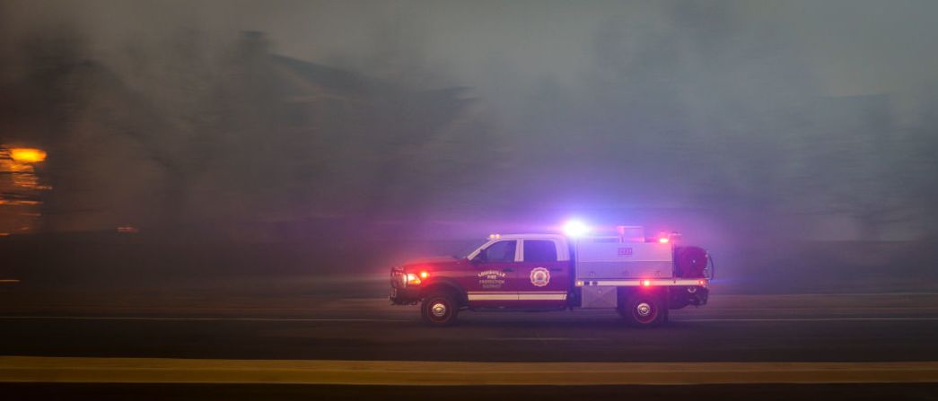 LOUISVILLE, CO - 30 DE DICIEMBRE: Un vehículo del Distrito de Protección contra Incendios de Louisville corre hacia otro punto de acceso en el vecindario de Centennial Heights mientras un incendio forestal en rápido movimiento arrasó el vecindario el 30 de diciembre de 2021 en Louisville, Colorado.