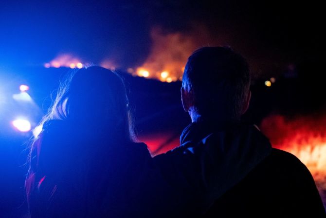 La Dra. Bonnie Abbott (izquierda) abraza a su esposo George mientras ven cómo las llamas envuelven las casas mientras el incendio Marshall se propaga por un vecindario en la ciudad de Superior en el condado de Boulder, Colorado, el 30 de diciembre de 2021.