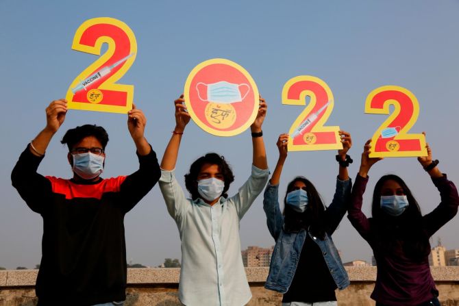 En Ahmedabad, en la India, la gente sostiene recortes que representan las vacunas contra el covid-19 y las mascarillas. Crédito: Ajit Solanki/AP