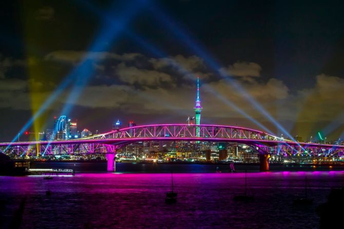 Un espectáculo de luces ilumina la Sky Tower y el Harbour Bridge en Auckland, Nueva Zelandia. El espectáculo de luces "Auckland Is Calling" sustituyó este año al tradicional espectáculo de fuegos artificiales de la ciudad. Crédito: Dave Rowland/Getty Images for Auckland Unlimited