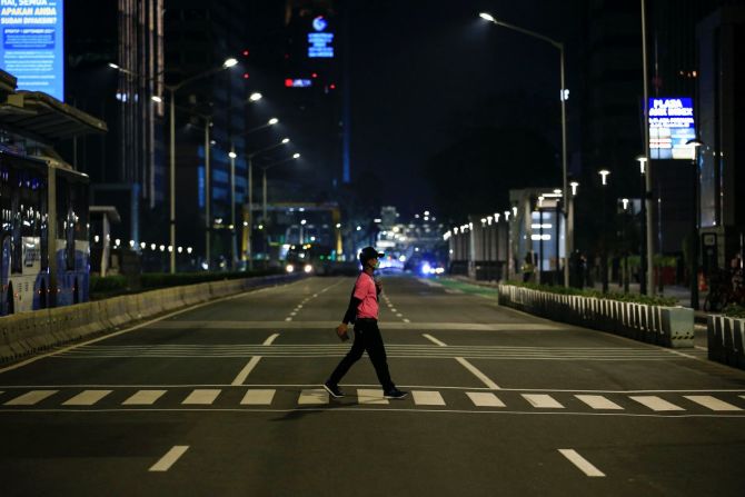 No todo fue un gran festejo. Un hombre cruza una avenida vacía cerca de una rotonda de Yakarta, Indonesia, donde la gente suele celebrar la Nochevieja. Crédito. Willy Kumiawan/Reuters