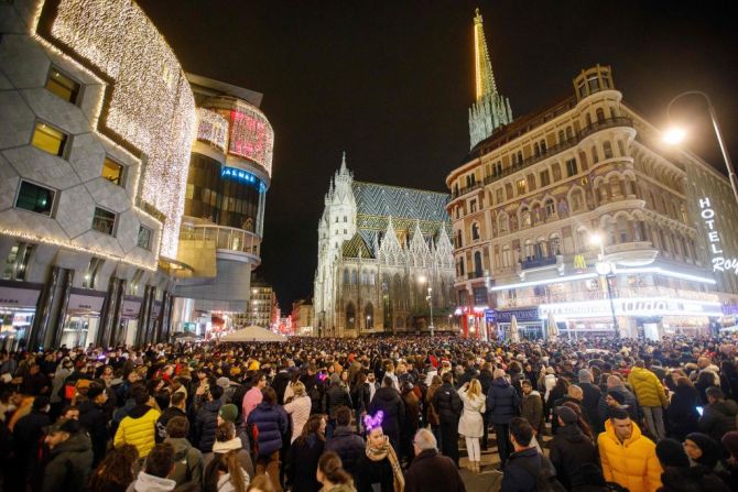 La gente espera para dar la bienvenida al año nuevo en la plaza Stephansplatz, cerca de la Catedral Stephansdom en el centro de la ciudad de Viena, Austria, en la víspera de Año Nuevo, el 31 de diciembre de 2021. -.