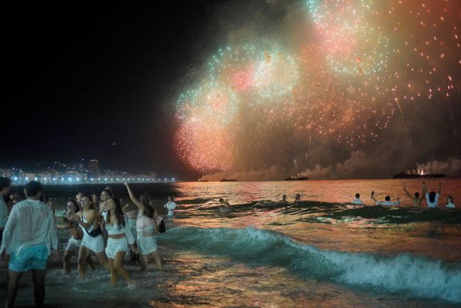 RIO DE JANEIRO, BRASIL - 1 DE ENERO: Los juerguistas disfrutan de los fuegos artificiales y celebran el Año Nuevo en la playa de Copacabana el 1 de enero de 2022 en Río de Janeiro, Brasil. Debido a la propagación de la variante Omicron y al aumento de casos, el alcalde Eduardo Paes anunció la cancelación de la celebración masiva y tradicional en la playa de Copacabana conocida como Reveillon.