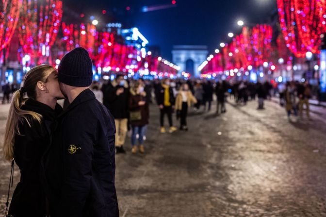 Una pareja se besa en la avenida de los Campos Elíseos en París a primera hora del día de Año Nuevo, 1 de enero de 2022.