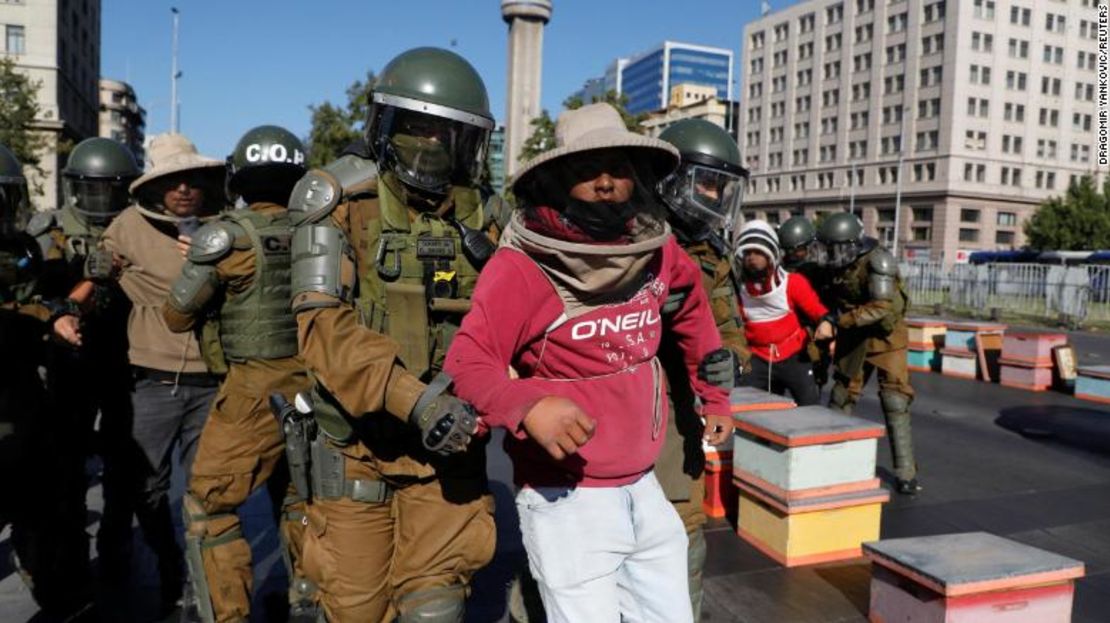Apicultores que exigían ayuda del gobierno en medio de una fuerte sequía son detenidos durante una protesta en Santiago de Chile este lunes.