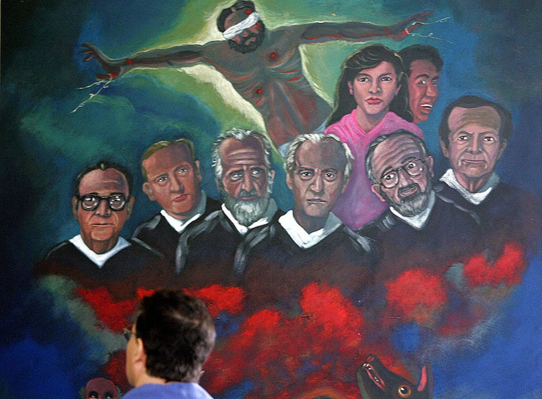 Un hombre observa una pintura mural el 16 de noviembre de 2006 en la Capilla de la Universidad Centroamericana, con los rostros de seis sacerdotes jesuitas españoles y dos de sus colaboradoras, asesinados por el ejército Salvadoreño en 1989 en San Salvador.