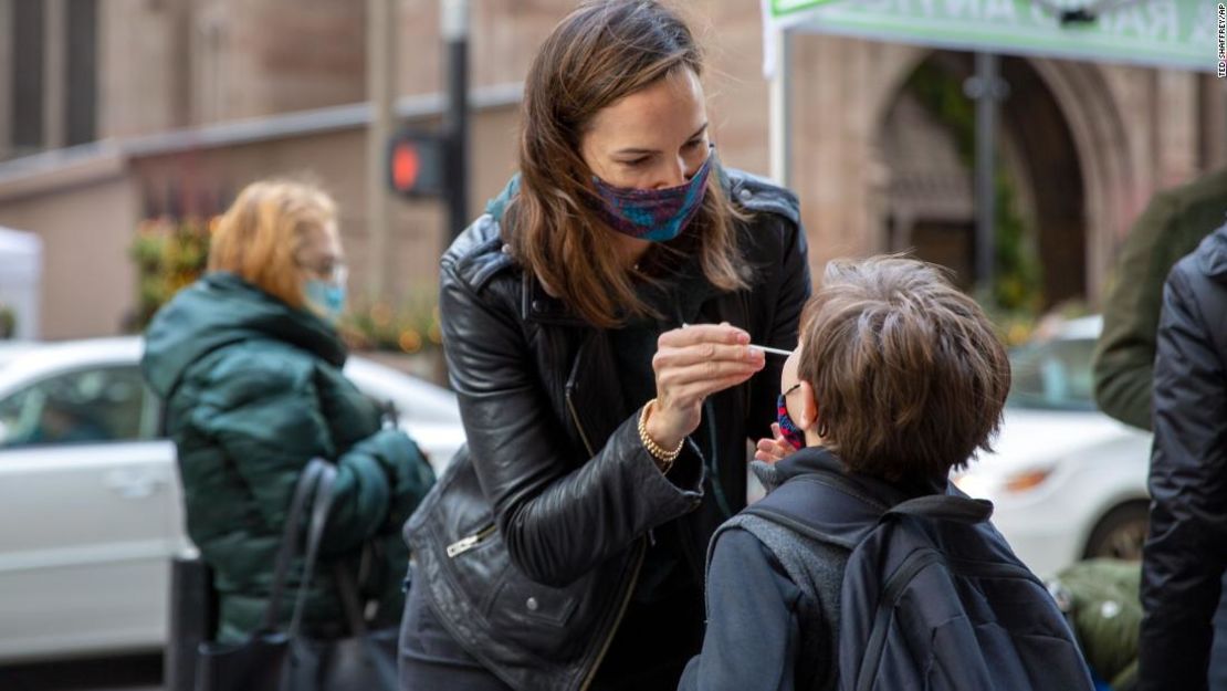 Katie Lucey administra una prueba de covid-19 a su hijo Maguire el 16 de diciembre en Nueva York. Crédito: AP Photo/Ted Shaffrey