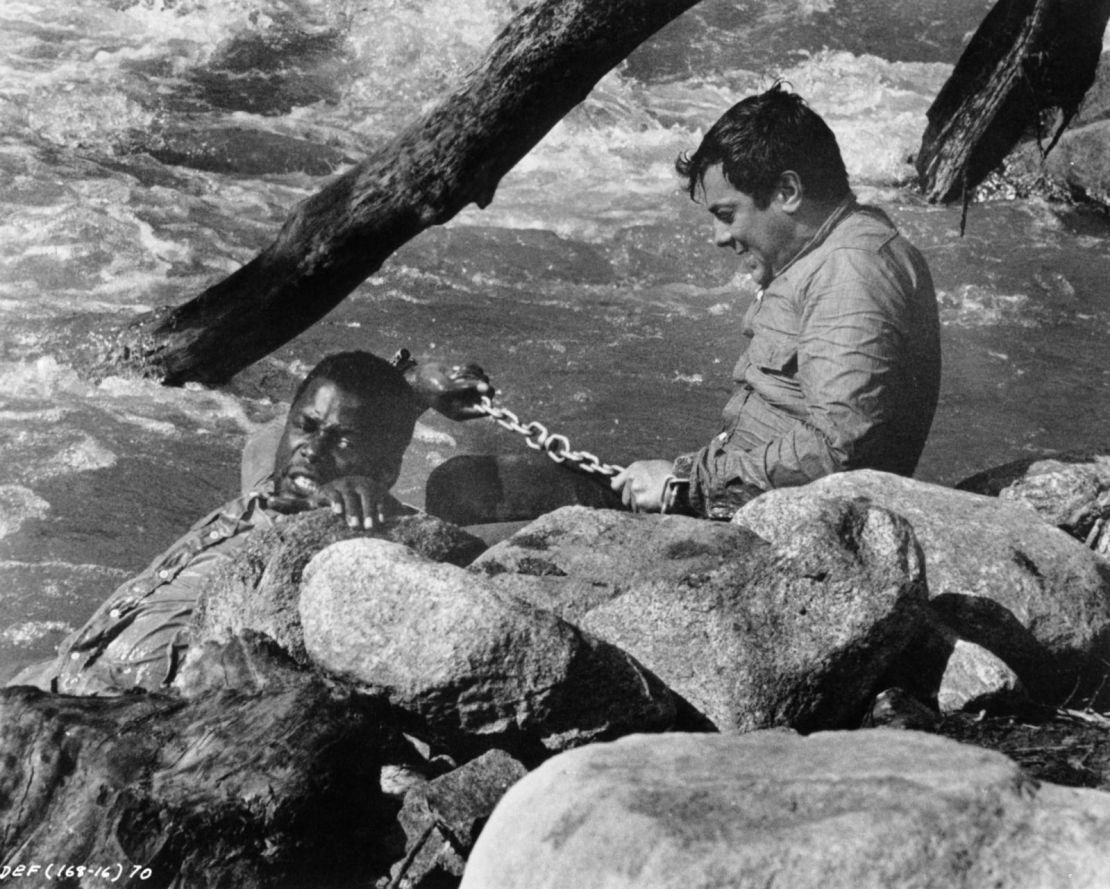 Poitier y Tony Curtis se encadenan en "The Defiant Ones", de 1958. Ambos fueron nominados al Oscar al mejor actor. Fue la primera vez que un hombre negro fue nominado para el premio. Crédito: United Artists/Moviepix/Getty Images