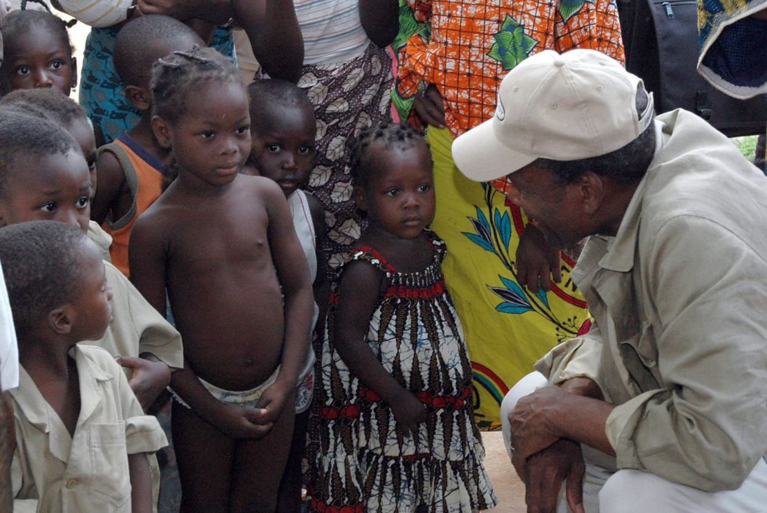 Poitier habla con niños en Porto Novo, Benín, durante una campaña de vacunación contra el sarampión organizada por la Cruz Roja en 2005. Crédito: Erick-Christian Ahounou/AFP/Getty Images