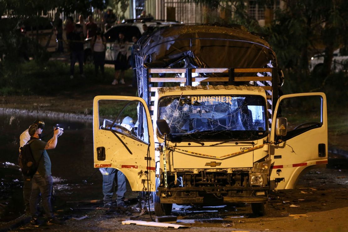 Personal de seguridad inspecciona un camión de la policía nacional destruido por un artefacto explosivo en Cali, Colombia, el 8 de enero de 2022.