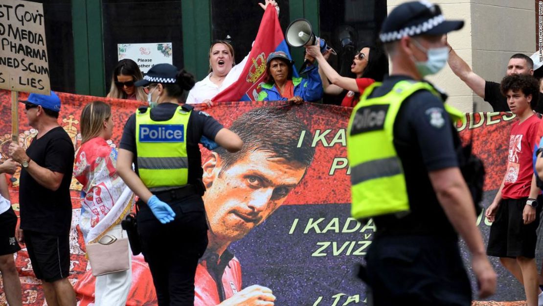 La gente sostiene pancartas afuera del Park Hotel donde el 20 veces campeón de Grand Slam Novak Djokovic se hospeda en Melbourne, Australia.