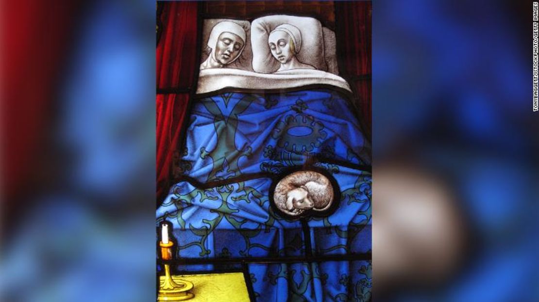 Un panel de una vidriera medieval que representa a un matrimonio durmiendo.