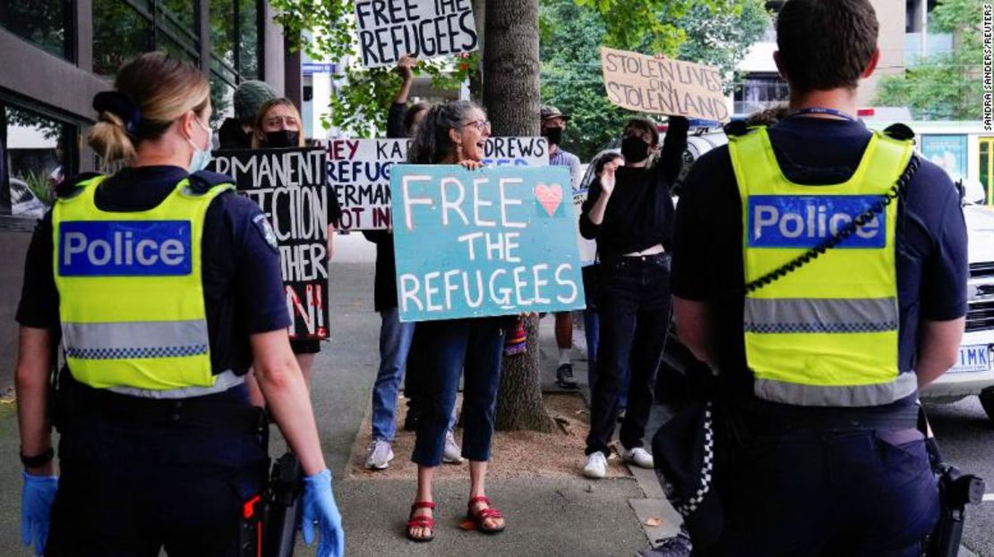 Policías observan a manifestantes a favor de los refugiados frente al Park Hotel, donde se cree que se encuentra detenido el tenista serbio Novak Djokovic, en Melbourne, Australia, el 10 de enero.