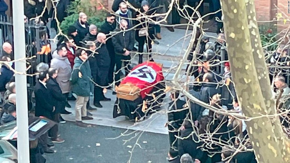 Una imagen facilitada por el portal italiano de noticias online Open muestra a personas reunidas alrededor de un ataúd cubierto con una esvástica fuera de la iglesia de Santa Lucía en Roma, Italia, el lunes.