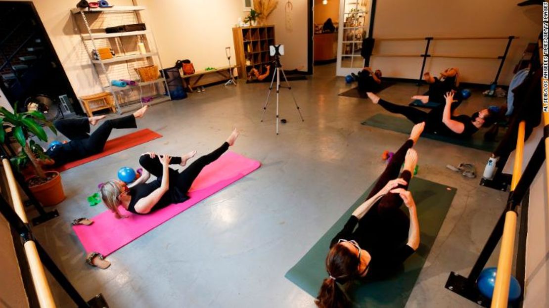 Martina Knight instruye una clase de barre reducida, con los participantes manteniendo su distanciamiento, en el Centro de Yoga SLO en San Luis Obispo, California, el 3 de marzo de 2021.