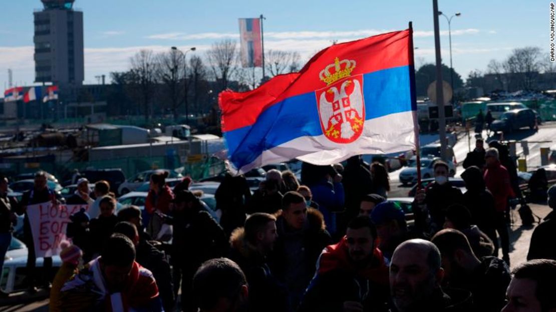 Seguidores oondean una bandera serbia cuando el tenista serbio Novak Djokovic llega al aeropuerto Nikola Tesla en Belgrado, Serbia, el lunes 17 de enero.