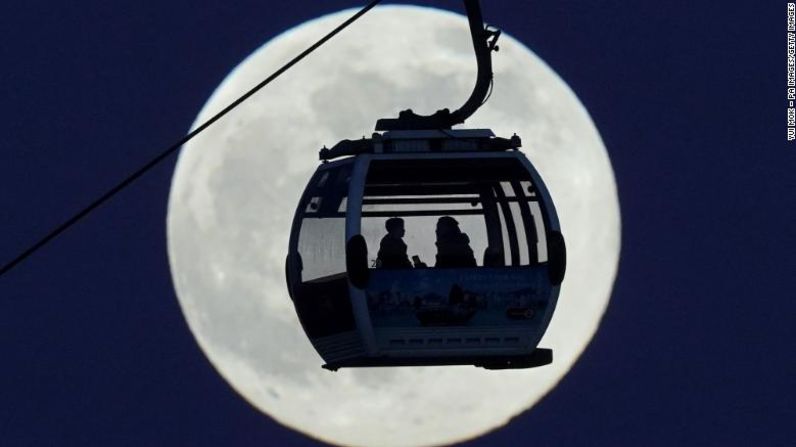 Además de luna de lobo, la luna llena de enero es conocida como luna vieja y luna de hielo. En la imagen, un teleférico pasa frente a la luna mientras cruza el río Támesis en Londres el lunes 17 de enero.