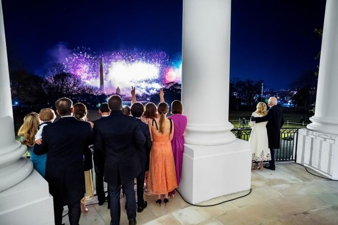 El presidente y la primera dama están acompañados por otros miembros de su familia mientras ven los fuegos artificiales desde la Casa Blanca en la noche de la inauguración. Estaban mirando el Monumento a Washington desde el balcón del Salón Azul.