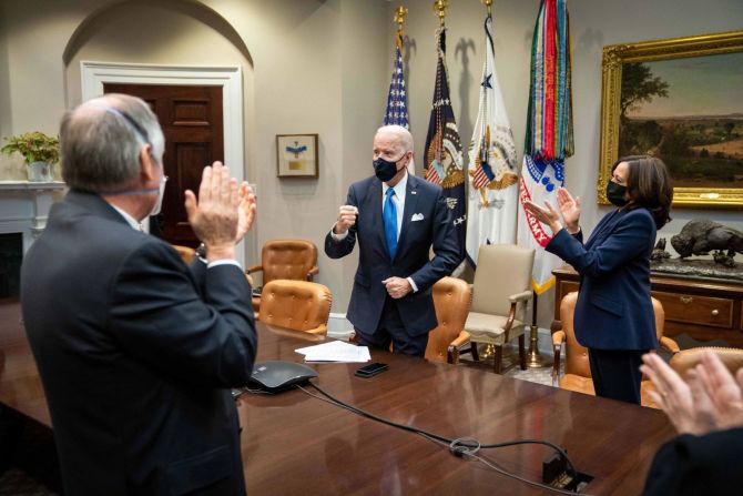 Biden y Harris, acompañados por personal de la Casa Blanca, aplauden mientras ven cómo la Cámara de Representantes aprueba un plan de ayuda económica de US$ 1,9 billones el 10 de marzo. El paquete de ayuda covid-19 había sido la primera y más urgente prioridad legislativa de Biden desde que asumió el cargo en enero.
