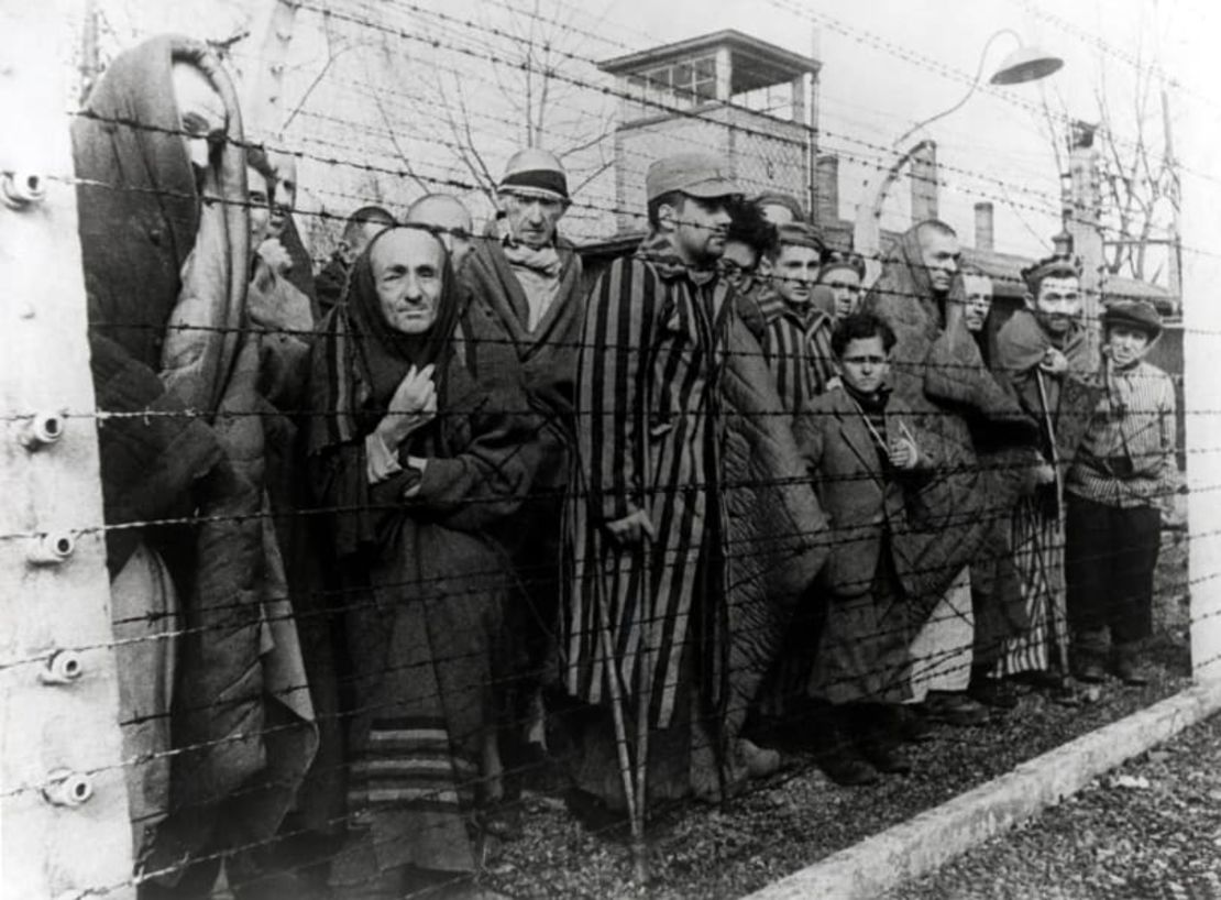 Los sobrevivientes de Auschwitz detrás de una cerca de alambre de púas. Algunos de los niños vestían ropa de adultos, proporcionada por los soldados soviéticos.