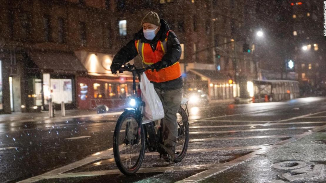 Un repartidor de alimentos en bicicleta pasea en la nieve el 28 de enero de 2022 en la ciudad de Nueva York.