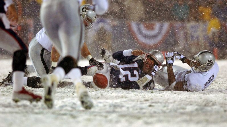 Brady pierde el balón después de ser golpeado por Charles Woodson de Oakland durante un juego de playoffs de la NFL en enero de 2002. Los Patriots recuperaron el balón y ganaron el juego, pero la controvertida jugada fue muy debatida. La "regla de pliegue" finalmente se derogó en 2013. Jim Davis/The Boston Globe/Getty Images