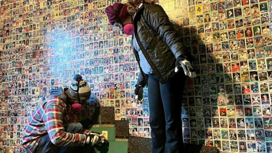 Melissa Brodt, fotografiada de pie, y su hijo Luke, encontraron cientos de cromos de béisbol pegados a la pared de un dormitorio mientras renovaban una casa.