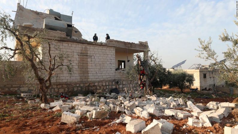 Unas personas inspeccionan una casa destruida en el pueblo del noroeste de Siria donde tuvo lugar la redada.