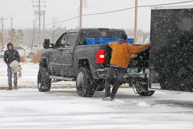 La gente trata de ayudar a un automovilista que quedó atrapado en la nieve en la ciudad de Oklahoma.