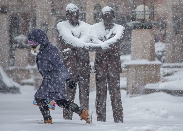 Una persona camina junto a una estatua de Martin Luther King Jr. y el reverendo Theodore Hesburgh en South Bend, Indiana, el miércoles 2 de febrero.