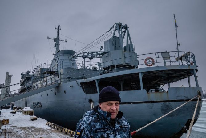 El capitán de la Armada de Ucrania, Oleksandr Hrigorevskiy, de pie en el muelle del puerto de Mariupol con su barco, el Donbas, detrás de él. “No espero una guerra en el mar con los rusos”, dijo.