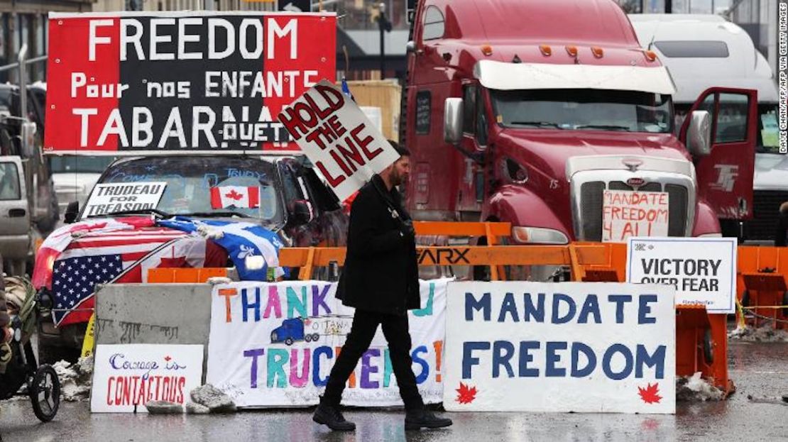 Un manifestante camina frente a camiones estacionados el 8 de febrero mientras los manifestantes en Ottawa, Canadá, continúan protestando por los mandatos de vacunación implementados por el primer ministro Justin Trudeau.