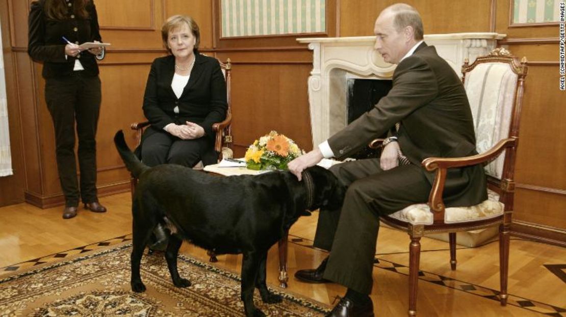 El presidente de Rusia Vladimir Putin acaricia a su perro durante una rueda de prensa con la canciller alemana Angela Merkel en Sochi, 2007.