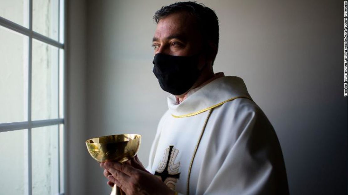 El padre Andrés Arango distribuye la Sagrada Comunión mientras usa una mascarilla en la Iglesia Católica de St. Gregory en Phoenix el 10 de mayo de 2020.