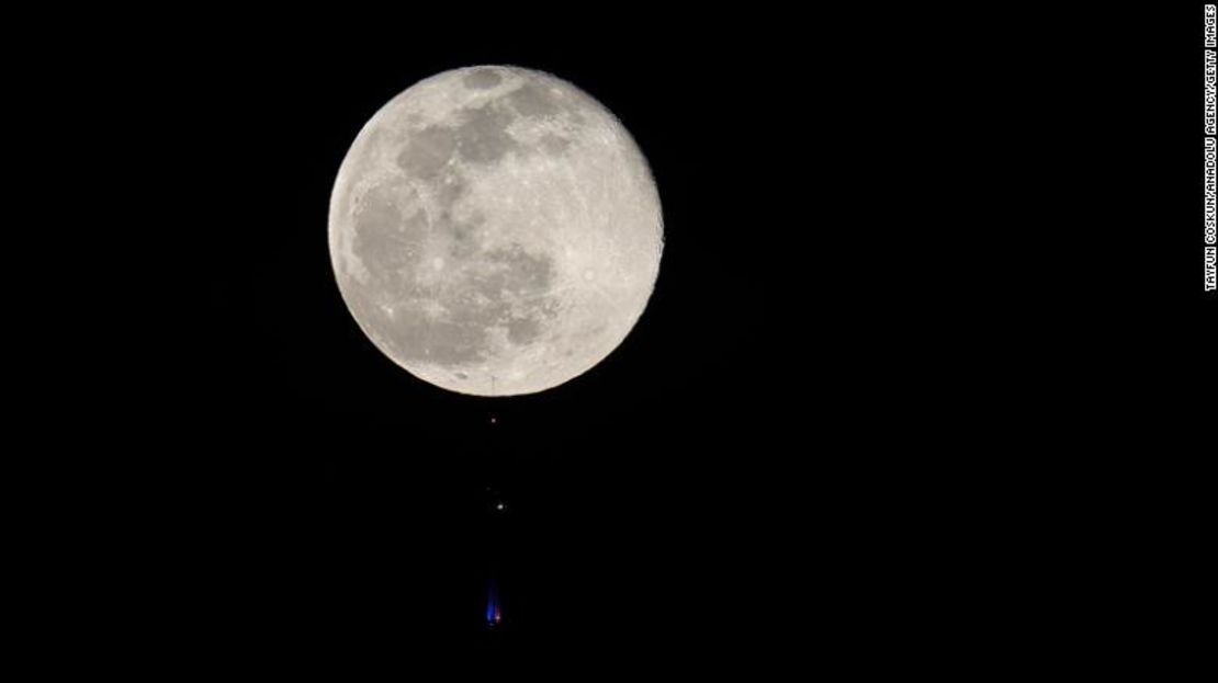 La luna de nieve se eleva sobre el edificio One Tower en el Bajo Manhattan de la ciudad de Nueva York, visto desde Newark, Nueva Jersey, el 27 de febrero de 2021.