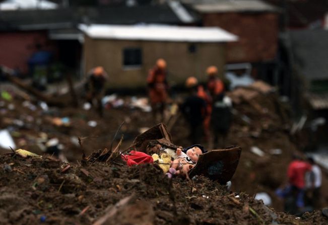 Una muñeca yace entre los escombros mientras los miembros del equipo de rescate buscan sobrevivientes.