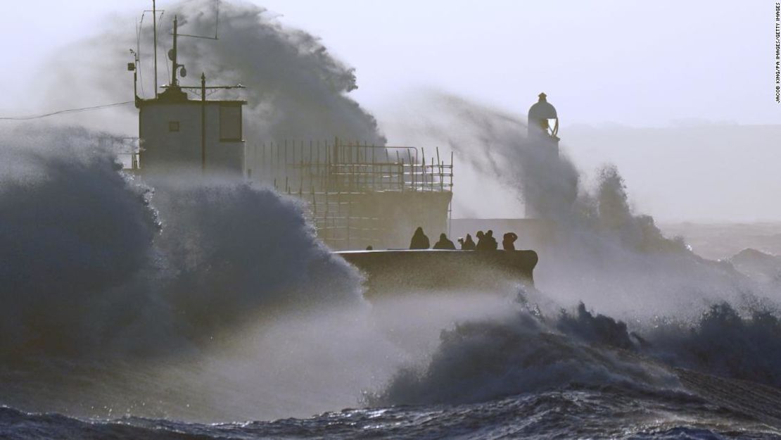 Olas chocan contra el malecón y el faro de Porthcawl en Bridgend, Gales, mientras la tormenta Eunice azota el Reino Unido este viernes.