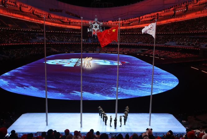 Las banderas de China y del Comité Olímpico Internacional se izan al inicio de la ceremonia de clausura.