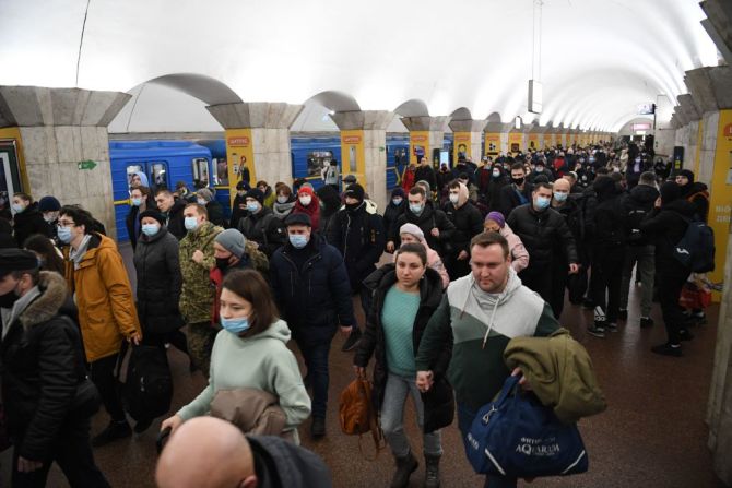 Personas, algunas con bolsos y maletas, caminan en una estación de metro en Kyiv a primera hora del 24 de febrero de 2022.
