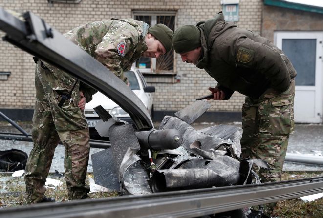 Agentes de policía inspeccionan los restos de un misil que cayó en la calle en Kyiv, Ucrania, el 24 de febrero.