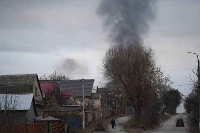Un residente en la ciudad de Hostomel camina por las calles en el noroeste de Kyiv, tras el ataque de las fuerzas rusas en Ucrania. Las fuerzas rusas y ucranianas luchan por el control de una base aérea en las afueras del norte de Kiev, según un oficial ucraniano.