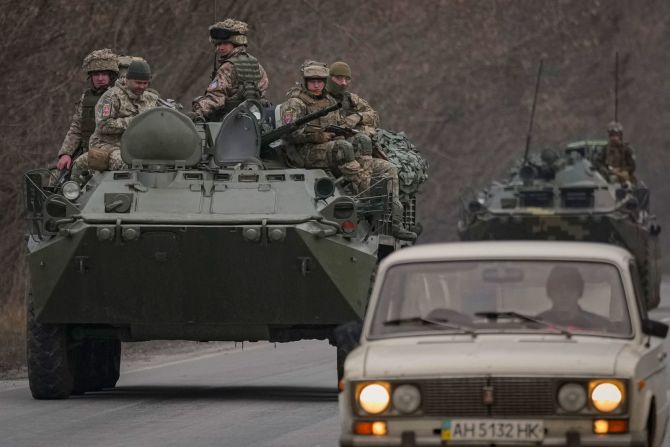 Militares ucranianos sentados encima de vehículos blindados que circulan por una carretera en la región de Donetsk, en el este de Ucrania, el 24 de febrero.
