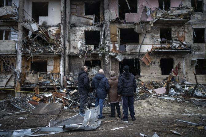 Al amanecer del 24 de febrero de 2022, explosiones resonaron en varias ciudades ucranianas, incluida la capital, Kyiv, en un amplio ataque del ejército ruso. En esta foto, varias personas evalúan los daños a un bloque de apartamentos luego de un presunto ataque con cohetes en un sector residencial de Kyiv, Ucrania, el 25 de febrero.