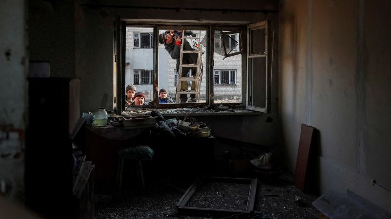 Estas personas intentan arreglar una casa dañada después de un bombardeo cerca de la ciudad de primera línea de Novoluhanske en la región ucraniana de Donetsk el 22 de febrero.