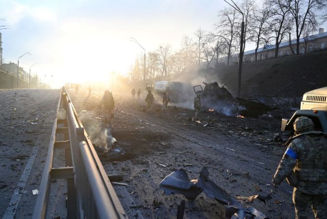 Miembros del servicio ucraniano recogen proyectiles sin explotar después de un enfrentamiento con un grupo de asalto ruso en la capital ucraniana de Kyiv en la mañana del 26 de febrero de 2022, según el personal del servicio ucraniano en el lugar. -.