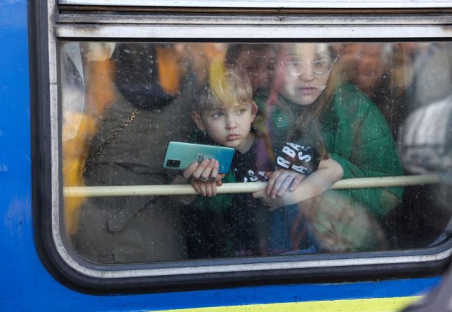 Una mujer y su hijo miran desde un tren que sale de la estación de trenes de Kyiv mientras viajan a Lviv el 25 de febrero. A medida que las tropas rusas avanzan hacia Kyiv, muchas personas se dirigen a Lviv, una ciudad en Ucrania cerca de la frontera con Polonia.